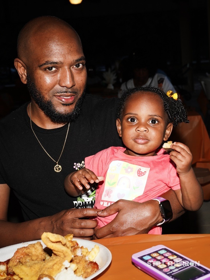A father feeding his daughter.