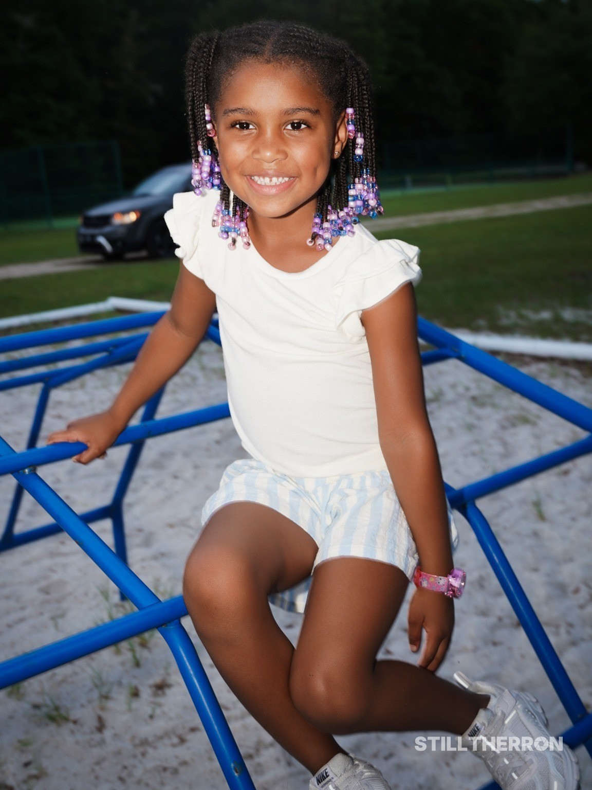A child posing on a jungle gym.